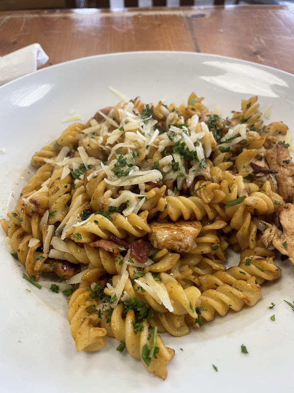 A bowl of homemade pasta with chicken, cheese and parsley